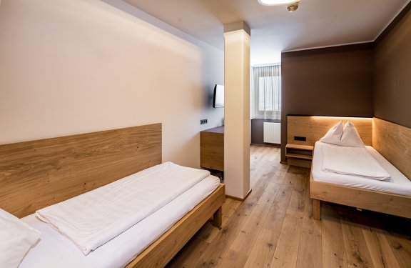 Zweibettzimmer mit Holzboden und abgetrennter Schlafnische
