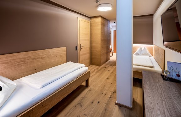 Zweibettzimmer mit Fernseher und gemütlicher Schlafnische
