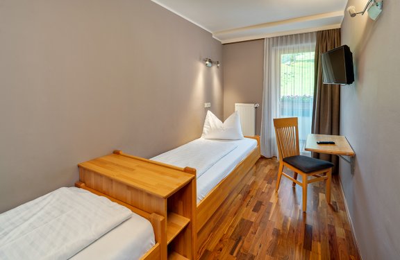 Schlafzimmer mit zwei Einzelbetten, Schreibtisch und TV