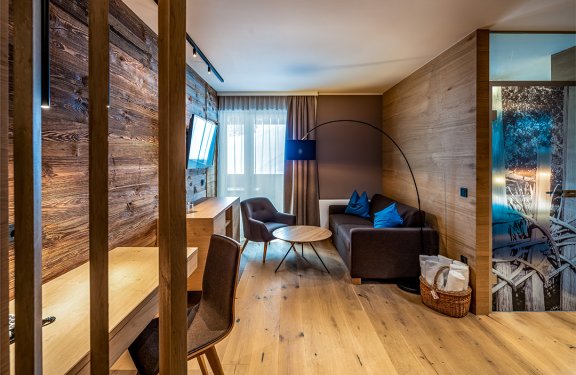 Gemütlicher Wohnbereich mit Holzwand, Sofa und runder Stehlampe