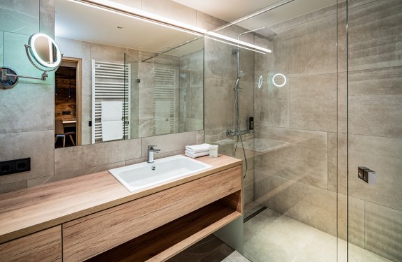 Modernes Bad mit Holzwaschtisch und großer Glasdusche