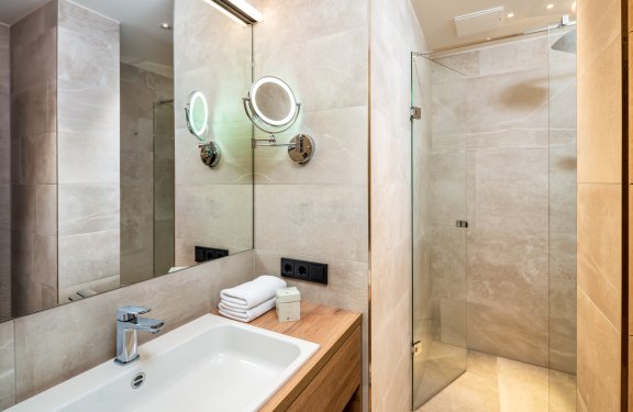 Modernes Bad mit begehbarer Dusche und beleuchtetem Kosmetikspiegel