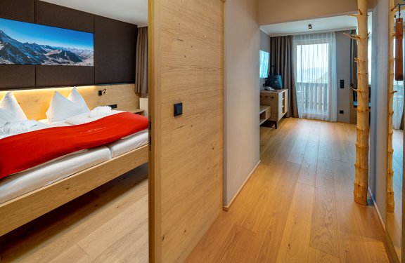 Blick vom Flur auf Schlafzimmer und Wohnbereich mit Balkonzugang