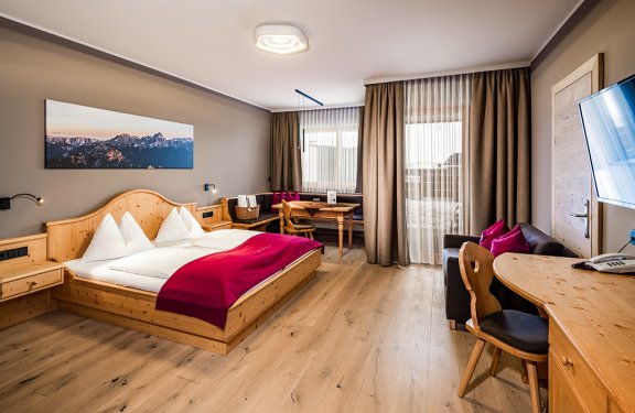 Gemütliches Zimmer im Alpin-Stil mit Doppelbett, Sofa und Sitzecke