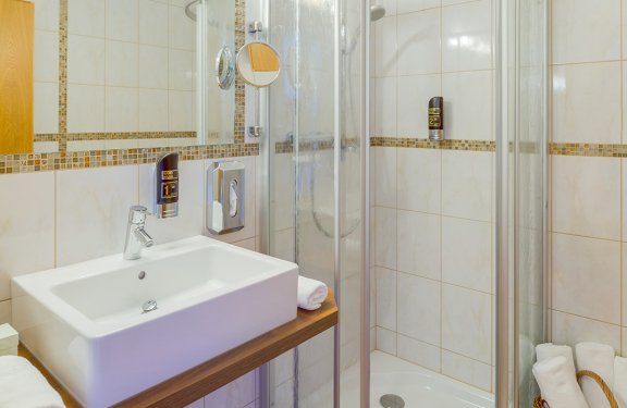 Waschbecken mit Spiegel und Duschkabine