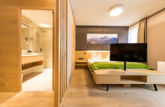 Zimmer mit Doppelbett, TV und direktem Zugang zum modernen Badezimmer